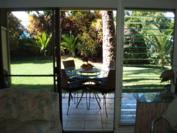A102 - Lower lanai from living room through to fully landscaped grounds